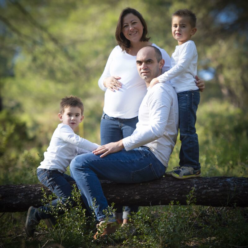 Photo de famille en extérieur avec une femme enceinte entourée de sa famille pour Lorie Diaz photographe