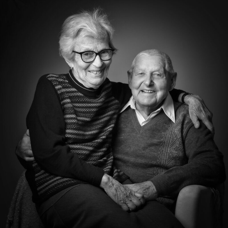 Portrait en noir et blanc en studio d'un couple sur fond gris pour Lorie Diaz photographe