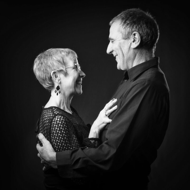 Portrait en noir et blanc en studio d'un couple sur fond noir pour Lorie Diaz photographe