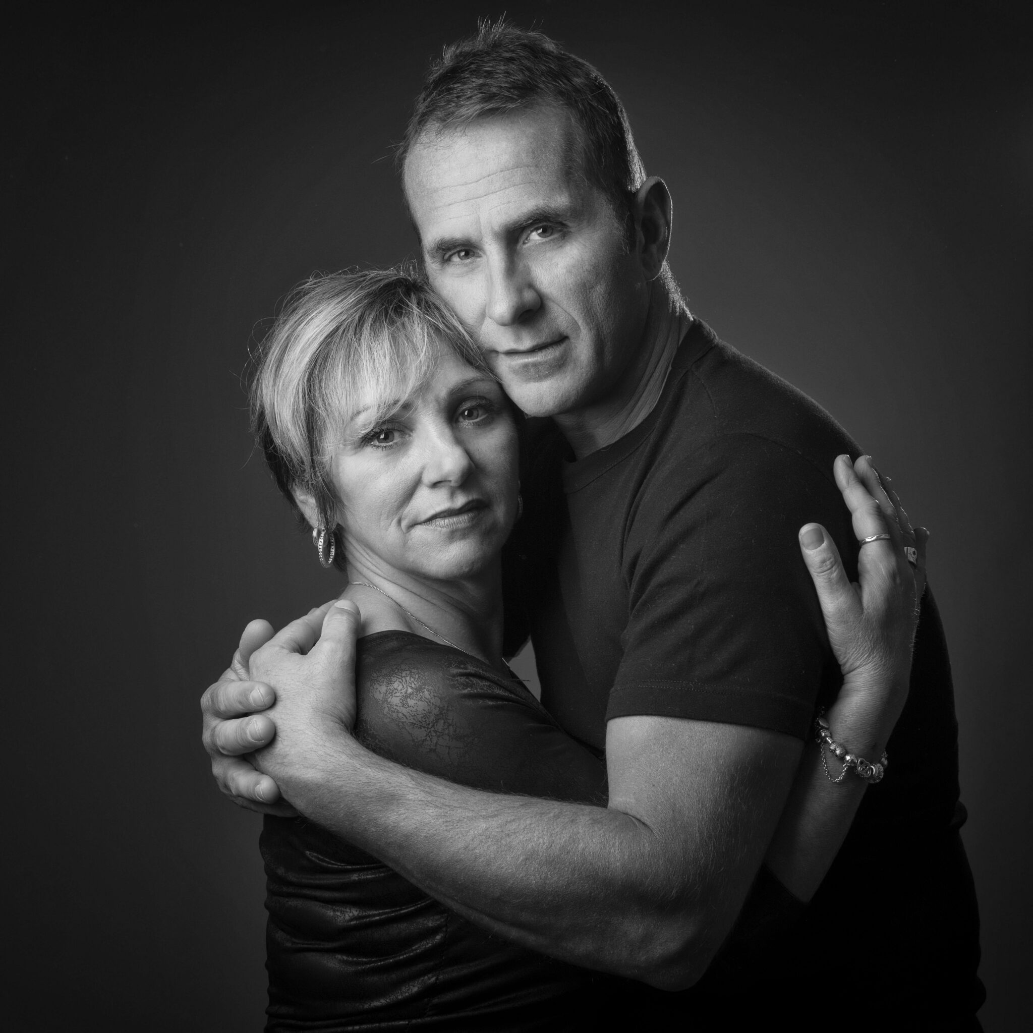 Portrait en noir et blanc en studio d'un couple sur fond gris pour Lorie Diaz photographe