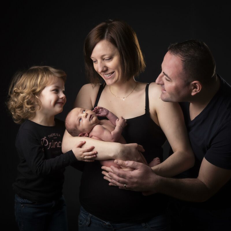 Portrait de famille avec un couple, un enfant et un bébé dans les bras de sa maman pour Lorie Diaz